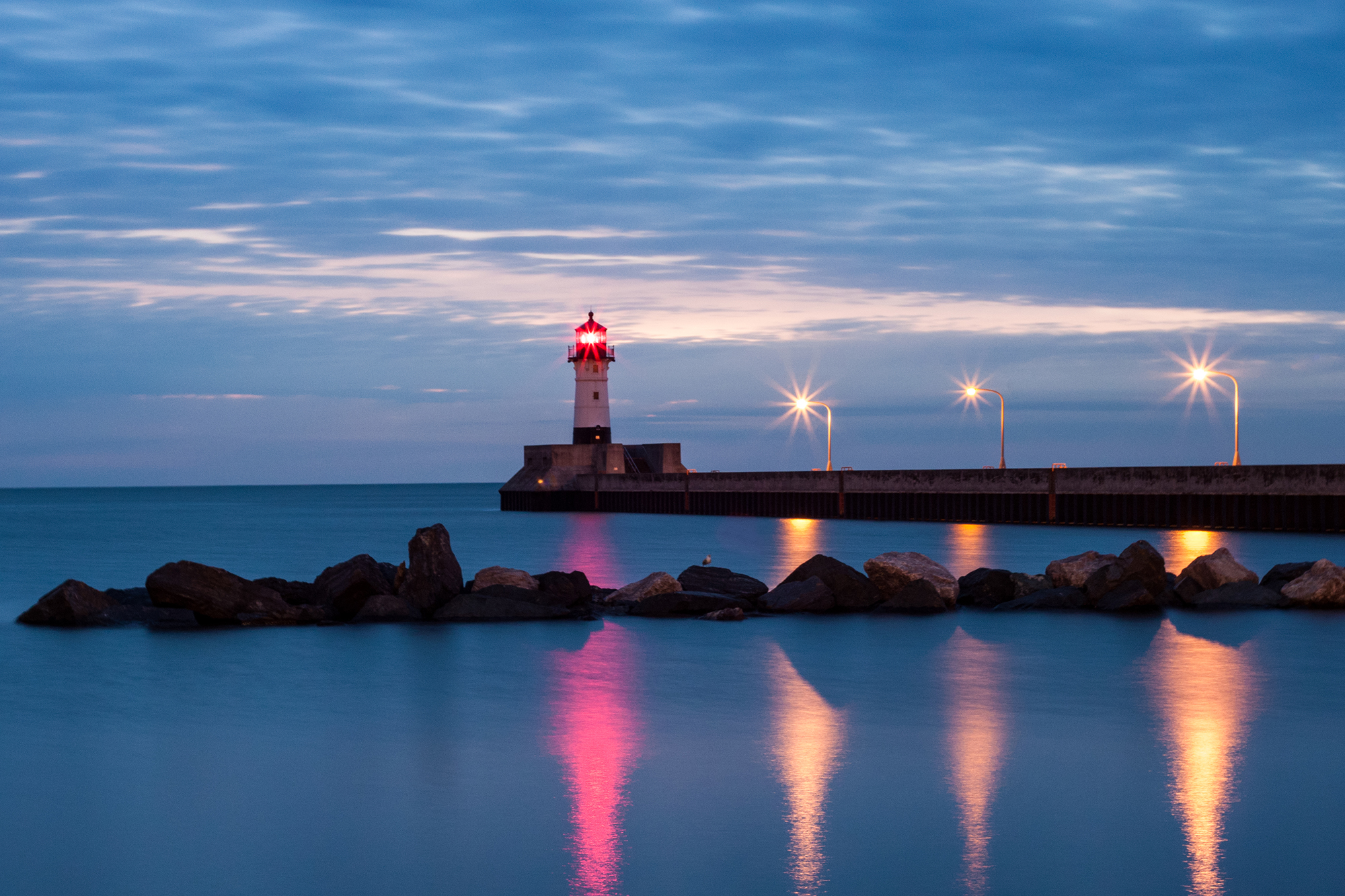 Colorful lights reflected on Lake Superior at the Canal Park Lighthouse in Duluth, MN